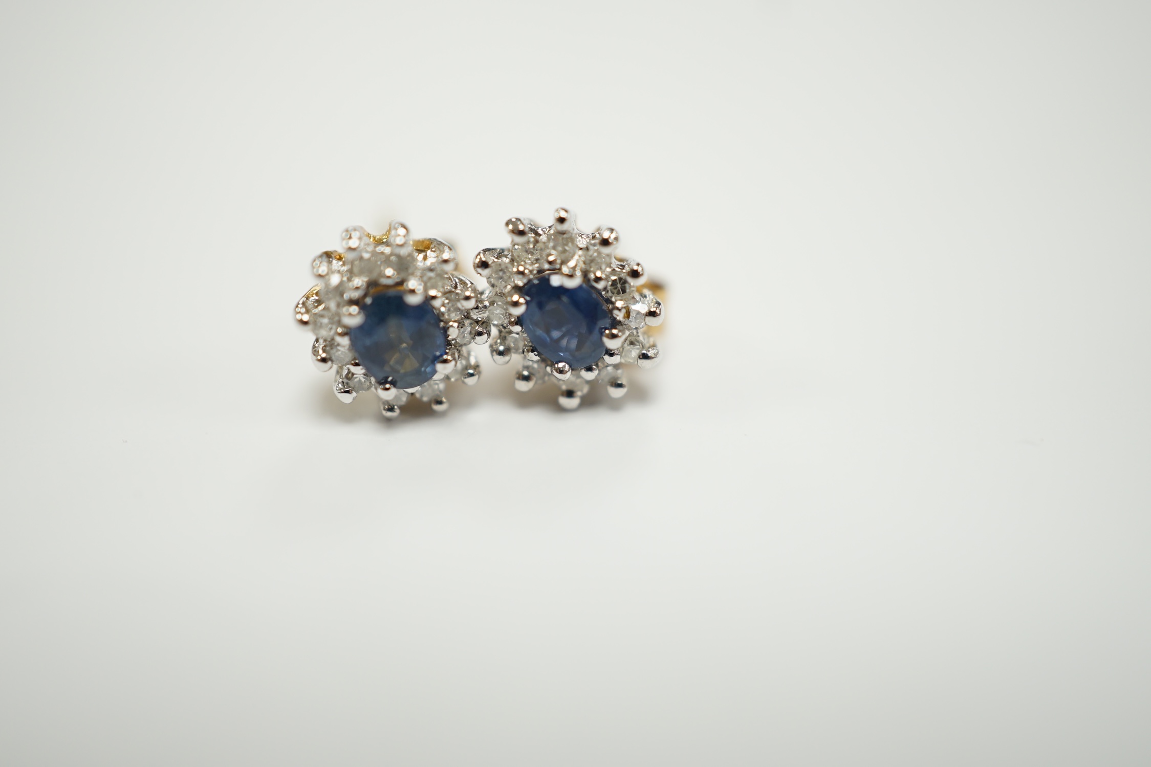 A pair of yellow metal, sapphire and diamond set oval cluster ear studs, 7mm, gross weight 1.3 grams.